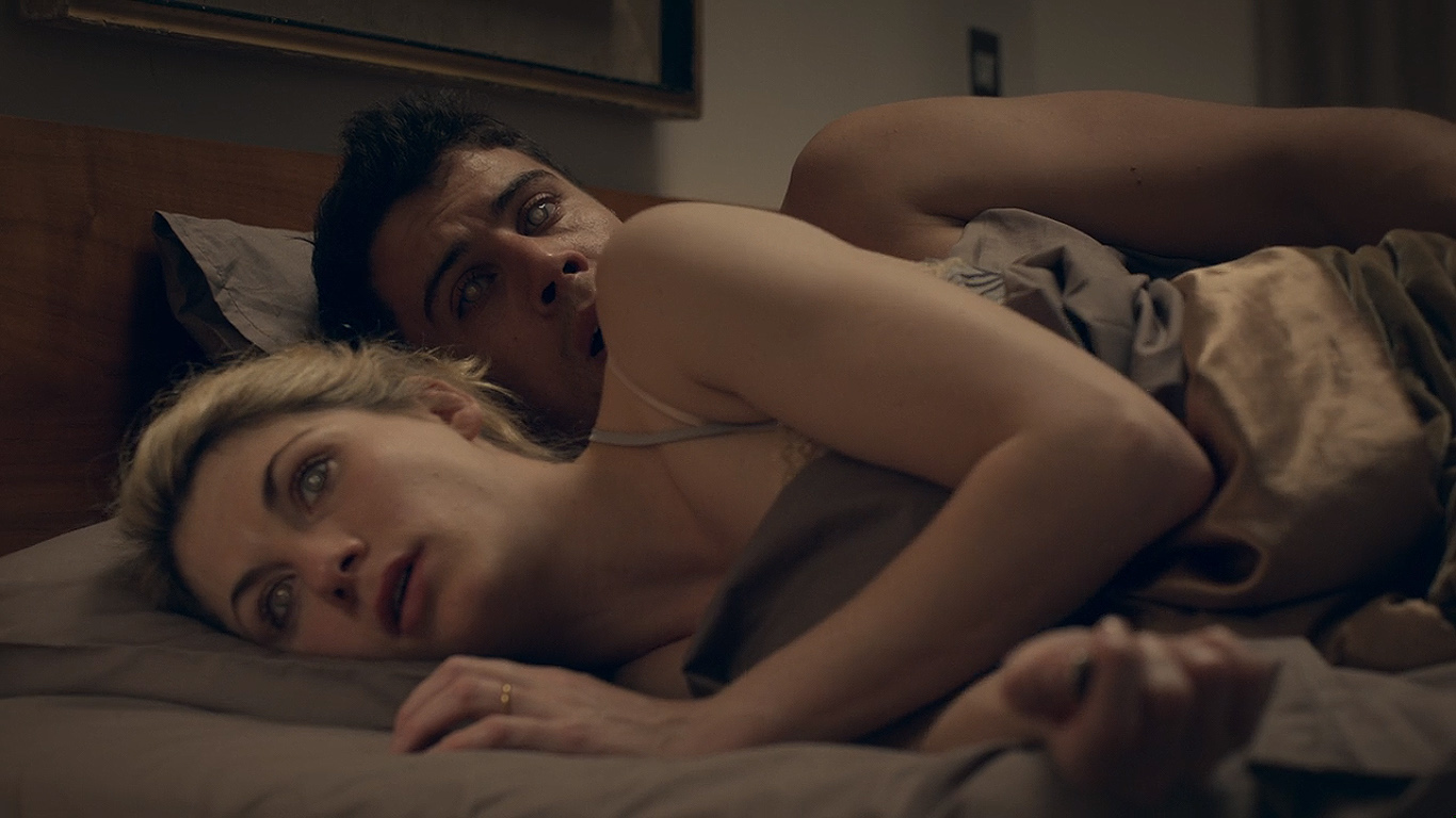 still from Black Mirror episode 'The Entire History of You' showing a couple in bed.